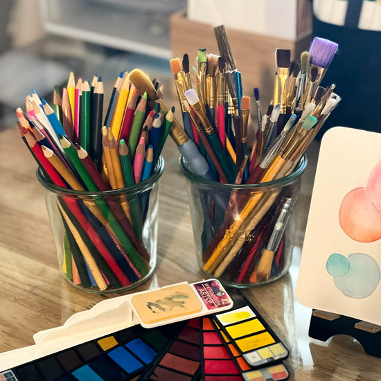 La Maison glass jars holding colored pencils and paint brushes